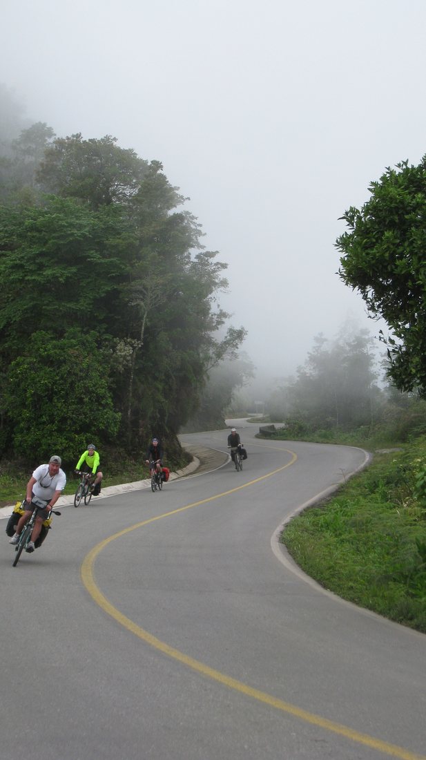 A loaded group descending a misty mountain road