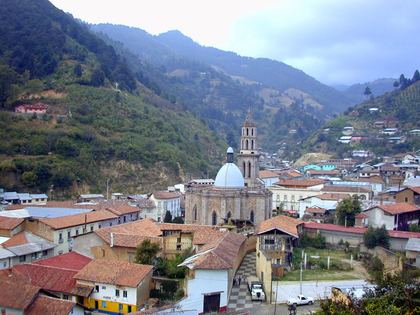 A mountain town of tiled roofs cupped in green hills