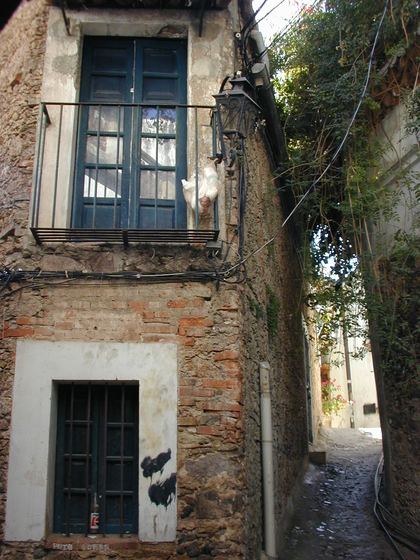 A weathered colonial facade and its wrought-iron window