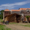 Some young goat herders walking past an old church.