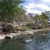 Xlacah cenote with Dzibilchaltun Mayan ruins in the backround.